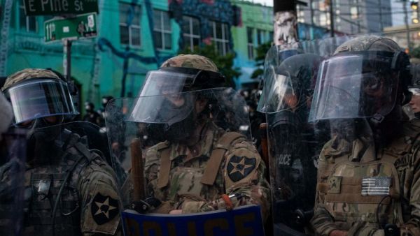 Washington National Guard personnel face off with demonstrators near the Seattle Police Departments East Precinct on June 6, 2020 in Seattle, Washington. This is the 12th day of protests since George Floyd died in Minneapolis police custody on May 25. David Ryder/Getty Images/AFP David Ryder / GETTY IMAGES NORTH AMERICA / Getty Images via AFP