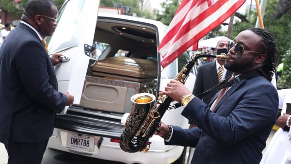 Taufeeq Wright plays a saxophone next to the hearse carrying the casket bearing the remains of Rayshard Brooks after his funeral service at the Ebenezer Baptist Church on June 23, 2020 in Atlanta, Georgia. Brooks was killed June 12 by an Atlanta police officer after a struggle during a field sobriety test in a Wendy's restaurant parking lot. Joe Raedle/Getty Images/AFP