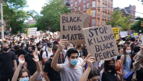 Protesters march and carry signs in the West Village as they demonstrate in outrage over the death of George Floyd, who died while in custody of the Minneapolis police, at a rally on May 30, 2020 in New York. AFP
