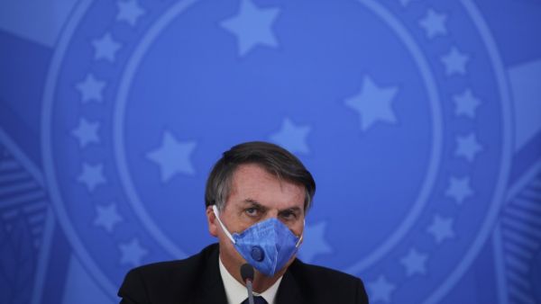 Brazil's President Jair Bolsonaro wears a face mask during a press conference on the coronavirus pandemic COVID-19 at the Planalto Palace in Brasilia, Brazil on March 20, 2020. Brazil's government on Friday drastically downgraded its growth projections for 2020 by 2.1 percent to practically zero (0.02 percent) due to the coronavirus pandemic. Sergio LIMA / AFP