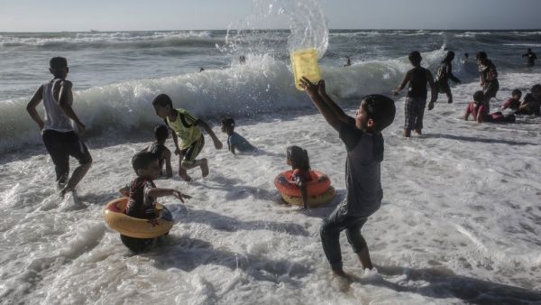 Palestinian children play in the waters of Rafah beach in the southern Gaza Strip on June 19, 2020. SAID KHATIB / AFP