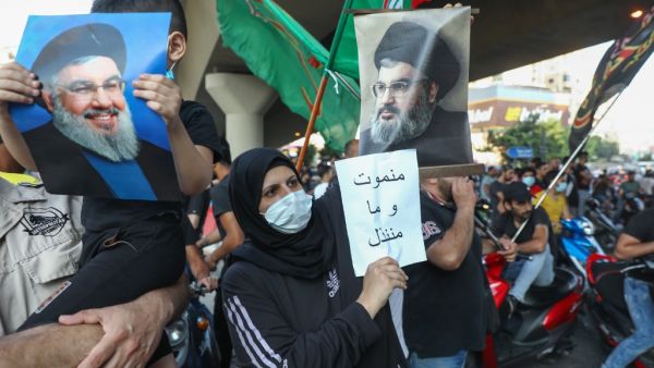 Supporters of the Lebanese Shiite movements Hezbollah and Amal lift pictures of Hezbollah's leader Hassan Nasrallah and anti-US placards as they protest a statement made by the US ambassador criticising the group, at a rally in the southern suburb of the capital Beirut, on June 28, 2020. ANWAR AMRO / AFP