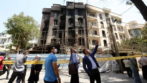 Iranians gather at the cordoned-off site of an explosion at the Sina At'har health centre in the upmarket northern neighbourhood of Tajrish in the capital Tehran on July 1, 2020. Iranian police questioned four people as part of investigations into a powerful explosion that killed 19 people at a Tehran clinic the night before, state media reported. ATTA KENARE / AFP