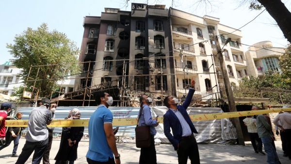 Iranians gather at the cordoned-off site of an explosion at the Sina At'har health centre in the upmarket northern neighbourhood of Tajrish in the capital Tehran on July 1, 2020. Iranian police questioned four people as part of investigations into a powerful explosion that killed 19 people at a Tehran clinic the night before, state media reported. ATTA KENARE / AFP