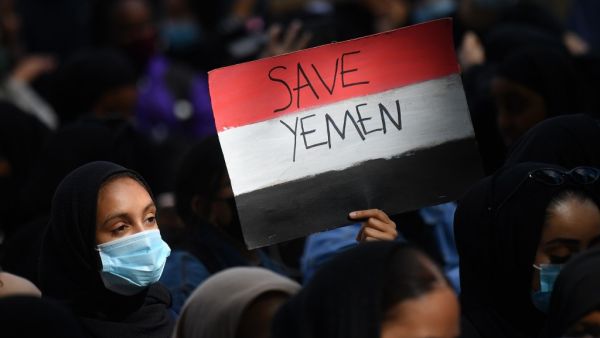 A protester holds a Yemeni flag-themed placard in Parliament Square in London on July 5, 2020, as she demonstrates against the continued conflict in Yemen. Yemen has been locked in conflict since the Huthis took control of Sanaa in 2014 and went on to seize much of the north. The crisis escalated when the Saudi-led coalition intervened the following year to support Yemen's internationally-recognised government. Tens of thousands of people, mostly civilians, have been killed and millions displaced in what th