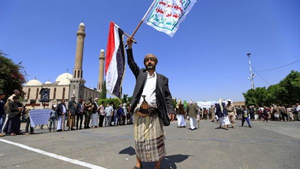 A Yemeni gunman loyal to the Huthi movement lifts flags during a rally in the capital Sanaa, to show support to the movement against the Saudi-led intervention in the country on July, 7, 2020. Mohammed HUWAIS / AFP
