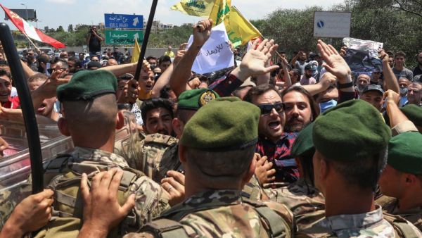 Lebanese soldiers block the road as supporters of Hezbollah and the Communist Party demonstrate at the entrance of Beirut's international airport on July 8, 2020, to denounce the visit of the US Central Command chief to the country. ANWAR AMRO / AFP
