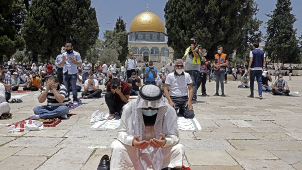 Palestinian Muslims perform the Friday prayer outside the Dome of the Rock Mosque, in Jerusalem's Al-Aqsa mosques compound, amid the novel coronavirus pandemic crisis on July 10, 2020. Ahmad GHARABLI / AFP