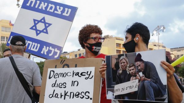 Israelis lift placards during a demonstration in Rabin Square in the central coastal city of Tel Aviv, on July 11, 2020, to protest the government's abandonment of the country's self-employed and other sectors after forcing their businesses to close under COVID-19 regulations, according to the organizers. Jack GUEZ / AFP