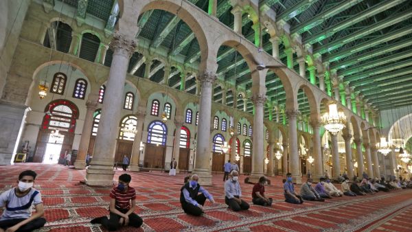 In this file photo taken on May 15, 2020, Syrian Muslims wearing face masks attend the Friday prayer at the Umayyad Mosque in Damascus, a temple of Jupiter transformed into a church in the 4th century, then into a mosque in the 7th, following the authorities' decision to allow prayers on Fridays in disinfected mosques with strict social distancing and protection measures to limit the spread of the coronavirus COVID-19 pandemic. Istanbul's iconic Hagia Sophia is to reopen for Muslim worship as a mosque after
