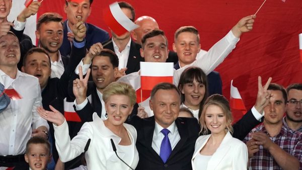 Polish President Andrzej Duda flashes V-signs after addressing supporters with his wife Agata as exit poll results were announced during the presidential election in Pultusk, Poland, on July 12, 2020. Poland's right-wing head of state Andrzej Duda was ahead by a tiny margin in the presidential run-off against Warsaw's liberal mayor, an exit poll on on July 12, 2020 showed, starting a tense wait for the official results JANEK SKARZYNSKI / AFP