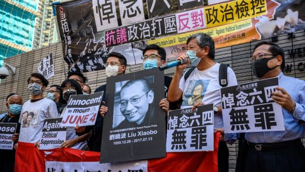 Supporters and activists, who led the June 4 candlelight vigil which commemorates the 1989 Tiananmen Square crackdown in Beijing, shout slogans before attending a mention at the West Kowloon Magistrates Court in Hong Kong on July 13, 2020. (AFP/File)