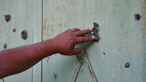A resident shows the gate of a house in the village of Aygepar in Tavush region damaged by recent shelling during armed clashes on the Armenian-Azerbaijani border on July 15, 2020. Defence officials in Armenia and Azerbaijan said fighting on their border subsided on July 15, 2020 after several days of deadly clashes raised fears of a major flare-up. At least 16 people on both sides were killed in three days of shelling that started Sunday between the ex-Soviet republics, which have been locked for decades i