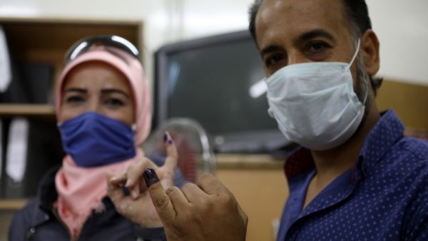 A man and a woman show their ink-stained fingers after voting at a polling station in the Syrian capital Damascus on July 19, 2020, during the parliamentary elections. Syrians vote today to elect a new parliament as the Damascus government grapples with international sanctions and a crumbling economy after retaking large parts of the war-torn country. Louai Beshara / AFP