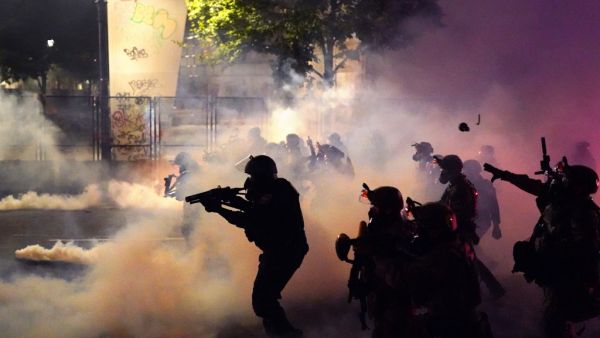 Federal officers deploy tear gas and less-lethal munitions while dispersing a crowd of about a thousand protesters in front of the Mark O. Hatfield U.S. Courthouse on Thursday, July 24, 2020 in Portland, Oregon. Protesters continued to clash with federal officers Friday morning as President Trump announced plans to deploy similar federal forces to other U.S. cities. Nathan Howard/Getty Images/AFP