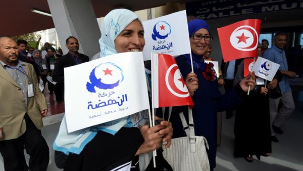 A file photo shows supporters of Tunisia's Islamist Ennahdha Party wave the national flag and the party flag during the opening of Ennahdha in Tunis. (AFP)