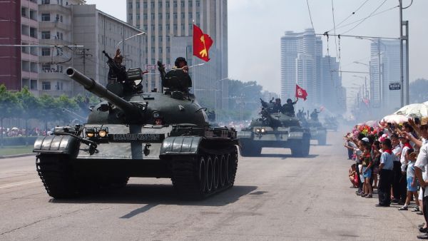 Military tanks parade in front of waving crowds through the streets of Pyongyang, North Korea. (Shutterstock/ File Photo)