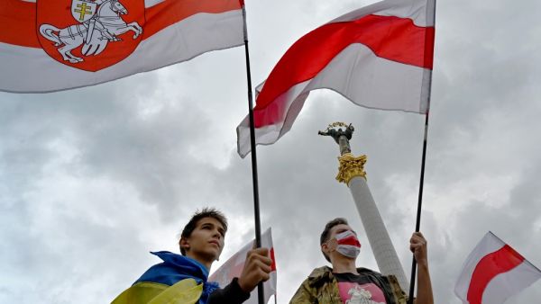 Members of the Belarus diaspora wave national flags during a "Free Belarus" rally at Independence Square in Kiev on August 1, 2020, a week before the Belarus presidential election. Sergei SUPINSKY / AFP
