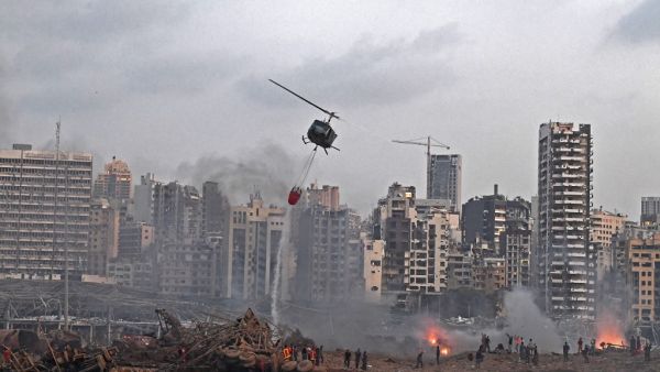 A helicopter try to put out multiple fires at the scene of the massive explosion that hit Beirut's port on August 4, 2020 in the heart of the Lebanese capital. Rescuers searched for survivors in Beirut on August 5 after a cataclysmic explosion at the port sowed devastation across entire neighbourhoods, killing more than 100 people, wounding thousands and plunging Lebanon deeper into crisis. AFP