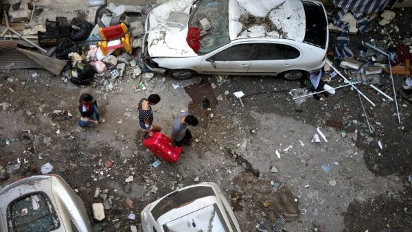 Lebanese carry a suitcase as they leave their damaged apartment in the trendy Beirut neighbourhood of Mar Mikhael on August 6, 2020 in the aftermath of a massive explosion in the Lebanese capital. PATRICK BAZ / AFP