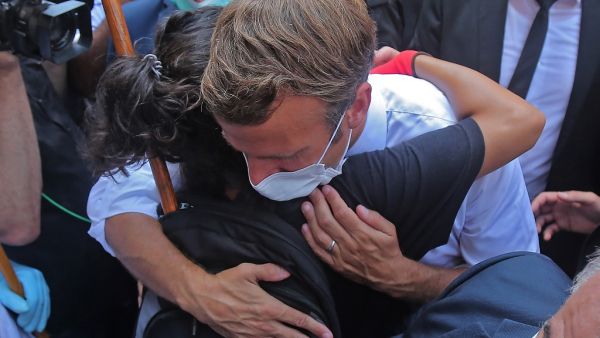 A Lebanese youth hugs French President Emmanuel Macron during a visit to the Gemmayzeh neighbourhood, which has suffered extensive damage due to a massive explosion in the Lebanese capital, on August 6, 2020. French President Emmanuel Macron visited shell-shocked Beirut, pledging support and urging change after a massive explosion devastated the Lebanese capital in a disaster that has sparked grief and fury. AFP