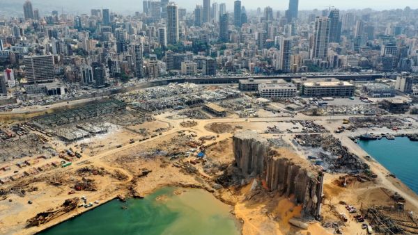 An aerial view taken on August 7, 2020, shows a partial view of the port of Beirut, the damaged grain silo and the crater caused by the colossal explosion three days earlier of a huge pile of ammonium nitrate that had languished for years in a port warehouse, leaving scores of people dead or injured and causing devastation in the Lebanese capital. The city of Beirut can be seen in the background. AFP