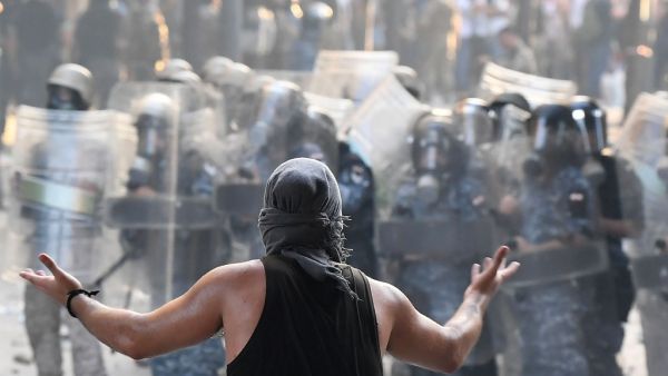 A Lebanese protester gestures towards security forces during clashes in downtown Beirut on August 8, 2020, following a demonstration against a political leadership they blame for a monster explosion that killed more than 150 people and disfigured the capital Beirut. AFP