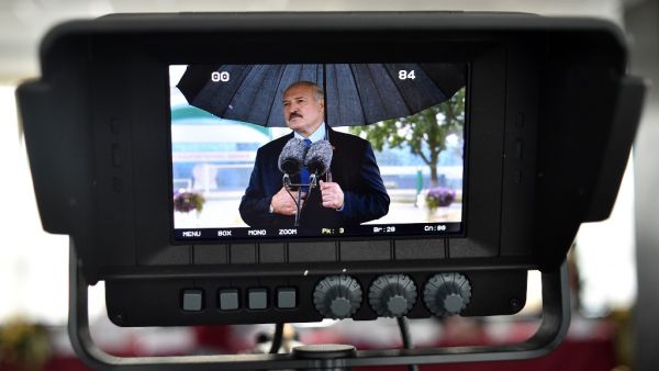 Belarus' President Alexander Lukashenko is seen on a screen while speaking to the media outside a polling station after casting his ballot in the presidential election in Minsk on August 9, 2020. Sergei GAPON / AFP