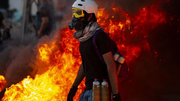 Iraqi demonstrators gather near burning tires during a protest near the governor's residence in the southern city of Basra, to protest assassinations and demand the resignation of top security officials in the southern Iraqi governorate, on August 17, 2020. Hussein FALEH / AFP