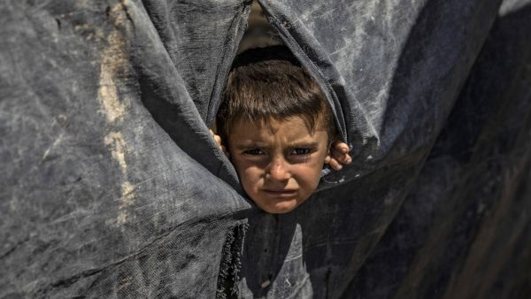 A boy looks out from a tent at the Kurdish-run al-Hol camp in the al-Hasakeh governorate in northeastern Syria on August 18, 2020, where families of Islamic State (IS) foreign fighters are held. Delil SOULEIMAN / AFP