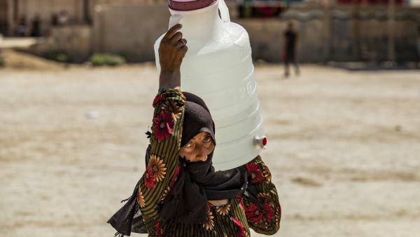 A displaced Syrian brings water back to their camp in a camp for the displaced in Syria's northeastern city of Hasakah on August 24, 2020. Delil SOULEIMAN / AFP