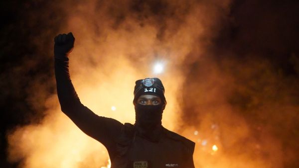 A protester holds his fist in the air during a protest against racial injustice and police brutality early in the morning on August 23, 2020 in Portland, Oregon. Nathan Howard / GETTY IMAGES NORTH AMERICA / Getty Images via AFP