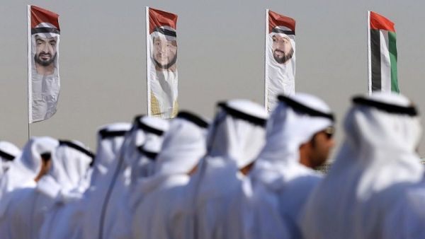 Emirati men perform a traditional dance in front of flags bearing portraits of Abu Dhabi's Crown Prince Sheikh Mohammed bin Zayed al-Nahyan, February 9, 2016. (AFP/Karim Sahib/ File)