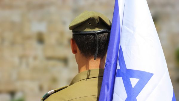 Israeli soldier with flag of Israel. (Shutterstock)