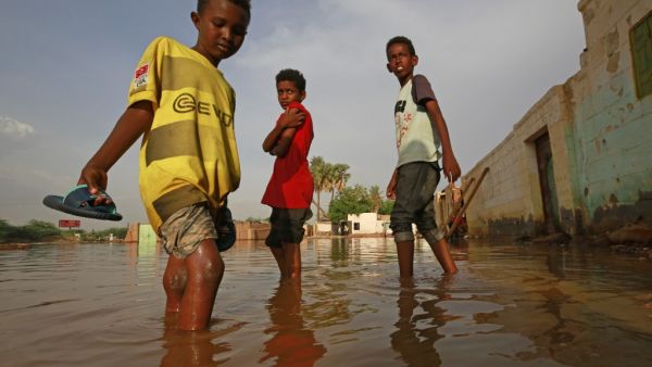 Sudanese boys make their way through a flooded street at the area of al-Qamayir in the capital's twin city of Omdurman, on August 26, 2020. Sudan on September 5 declared the imposition of a three-month state of emergency nationwide after record-breaking torrential floods caused by more than a month heavy rains left dozens dead and 100,000 damaged properties in their wake, in one of the worst natural disasters in decades, according to state news agency SUNA. ASHRAF SHAZLY / AFP