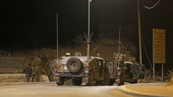 Israeli soldiers gather near the site of a fire on the border fence with Syria, near the Druze village of Majdal Shams in the Israel-annexed Golan Heights on August 31, 2020. JALAA MAREY / AFP