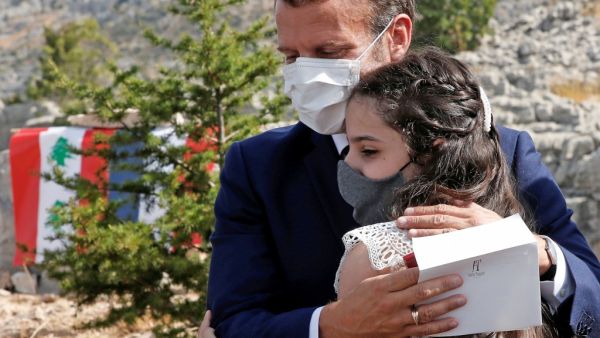 French President Emmanuel Macron hugs a blast victim while attending a ceremony to mark Lebanon's centenary in Jaj Cedars Reserve Forest, northeast of the capital Beirut, on September 1, 2020. GONZALO FUENTES / POOL / AFP