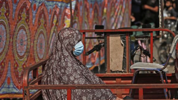 A Palestinian woman, working in the public sector, sits in the back of a truck in Gaza City on September 1, 2020, amid a lockdown due to increasing cases of COVID-19 infections. MAHMUD HAMS / AFP