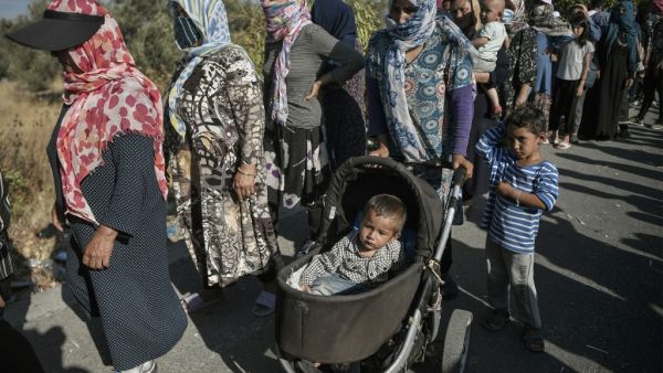 Refugees and migrants wait for a food distribution at a road where thousands are living with out shelter, near the Kara Tepe camp on the island of Lesbos on September 13, 2020. Over 11,000 people -- including some 4,000 children -- have been sleeping rough since the notoriously overcrowded and unsanitary camp of Moria burned down this week..Aided by army bulldozers, work crews have worked round-the-clock to erect a makeshift camp for 3,000 people a few kilometres from the ruins of Moria where the first 500 