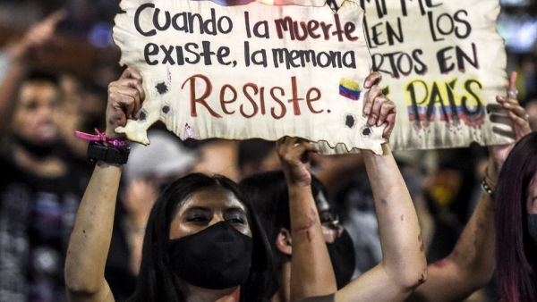 A woman holds a sign reading “When death exists, memory resists” during a protest against police brutality in Medellin, Colombia, on September 14, 2020. (AFP)