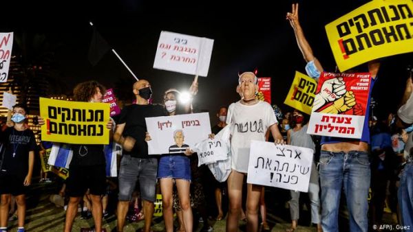 Israeli protesters wave national flags and chant slogans against the government near the prime minister's residence in Jerusalem. (AFP)