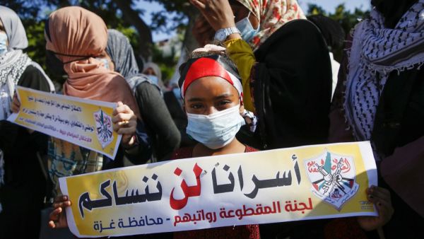 A Palestinian girl, wearing a protective face mask, takes part in a demonstration to how their support to prisoners held in Israeli jails, in Gaza City on October 5, 2020. MOHAMMED ABED / AFP