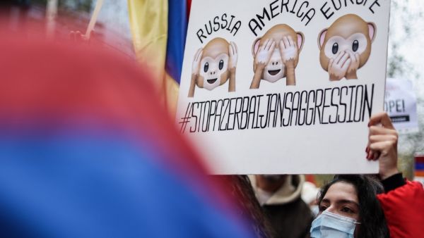 A member of the Belgian Armenian community hold a placard as they gather to protest against the conflict between Azerbaijan and Armenia over Nagorno-Karabakh, near the European Commission headquarters in Brussels, on October 7, 2020. Kenzo TRIBOUILLARD / AFP