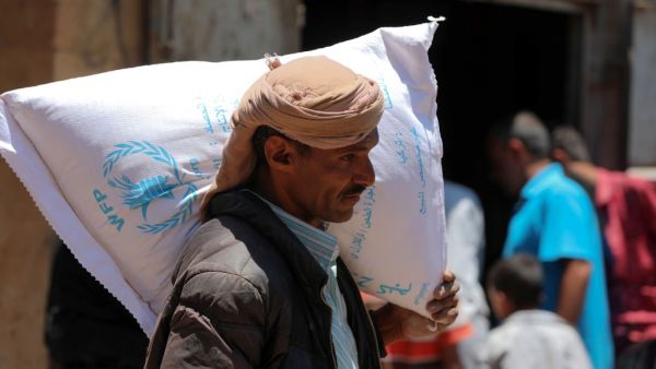 A Yemeni man receives humanitarian aid, donated by the World Food Programme (WFP), in the country's third city of Taez, on October 10, 2020. AHMAD AL-BASHA / AFP