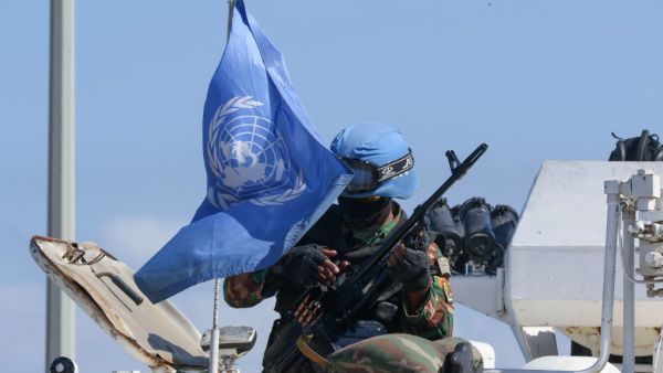 A United Nations peacekeeping force (UNIFIL) soldier examines a weapon as he sits atop a vehicle patrolling the Lebanese southern coastal area of Naqura by the border with Israel, on October 11, 2020. Mahmoud ZAYYAT / AFP