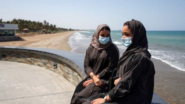 Omanis, wearing protective face masks, sit on the corniche in the capital Muscat on October 12, 2020, during the coronavirus pandemic. MOHAMMED MAHJOUB / AFP