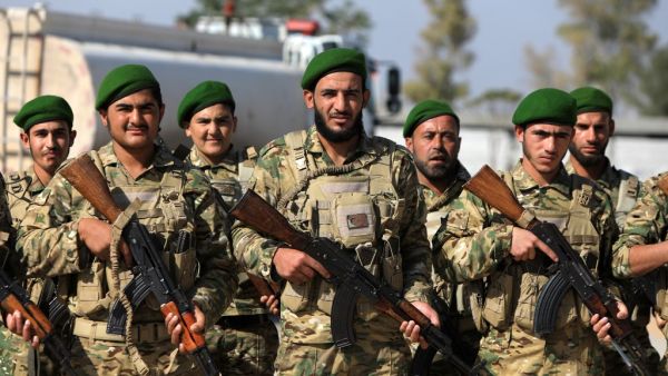 Turkey-backed Syrian fighters take part in a parade in the rebel-controlled town of Tal Abyad in Syria's northern Raqa province, on October 13, 2020. Bakr ALKASEM / AFP