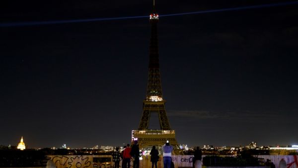 The lights of the Eiffel Tower in Paris are switched-off on October 21, 2020, during a national homage to French teacher Samuel Paty who was beheaded for showing cartoons of the Prophet Mohamed in his civics class. (AFP)