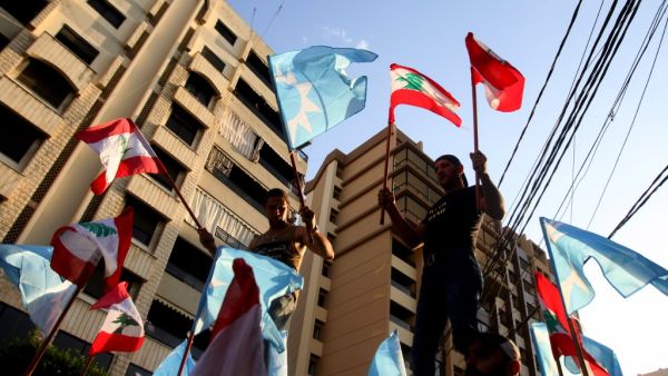 Supporters of Saad Hariri's Future Movement Party wave the party flag and the national flag during a parade to celebrate him being tasked with forming a new government in Lebanon's southern city of Sidon (Saida) on October 22, 2020. Three-time Lebanese prime minister Saad Hariri was renamed to the post to create a reform-orientated cabinet that can lift the country out of its worst economic crisis in decades. Mahmoud ZAYYAT / AFP
