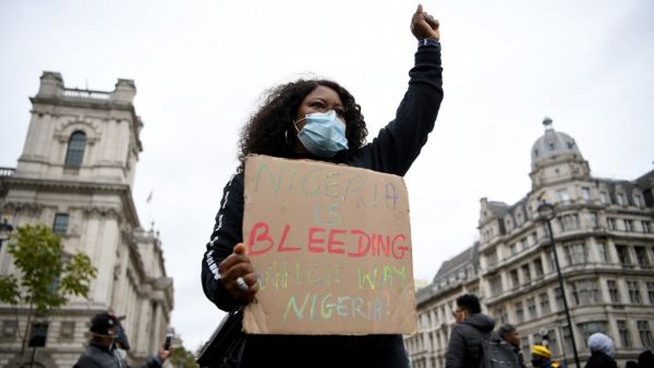 Protestors carry placards as they gather for a protest against police brutality in Nigeria, in Parliament Square in central London on October 24, 2020. (AFP/File Photo)